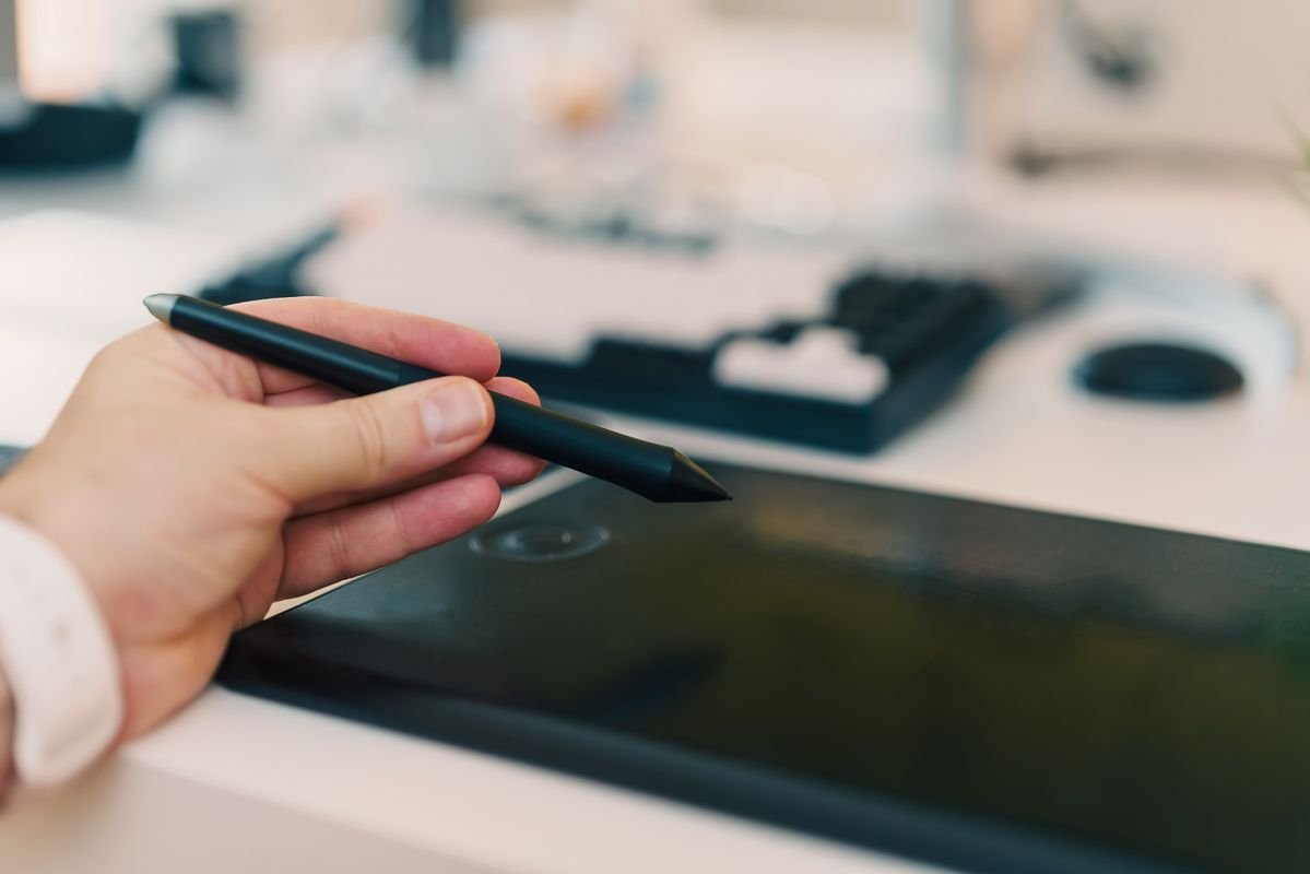 Illustrateur numérique dessinant sur une tablette graphique avec un stylet